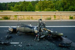 A crashed motorcycle lying on its side in an empty roadway; motorcycle accidents can lead to serious injuries that require extensive medical treatment.